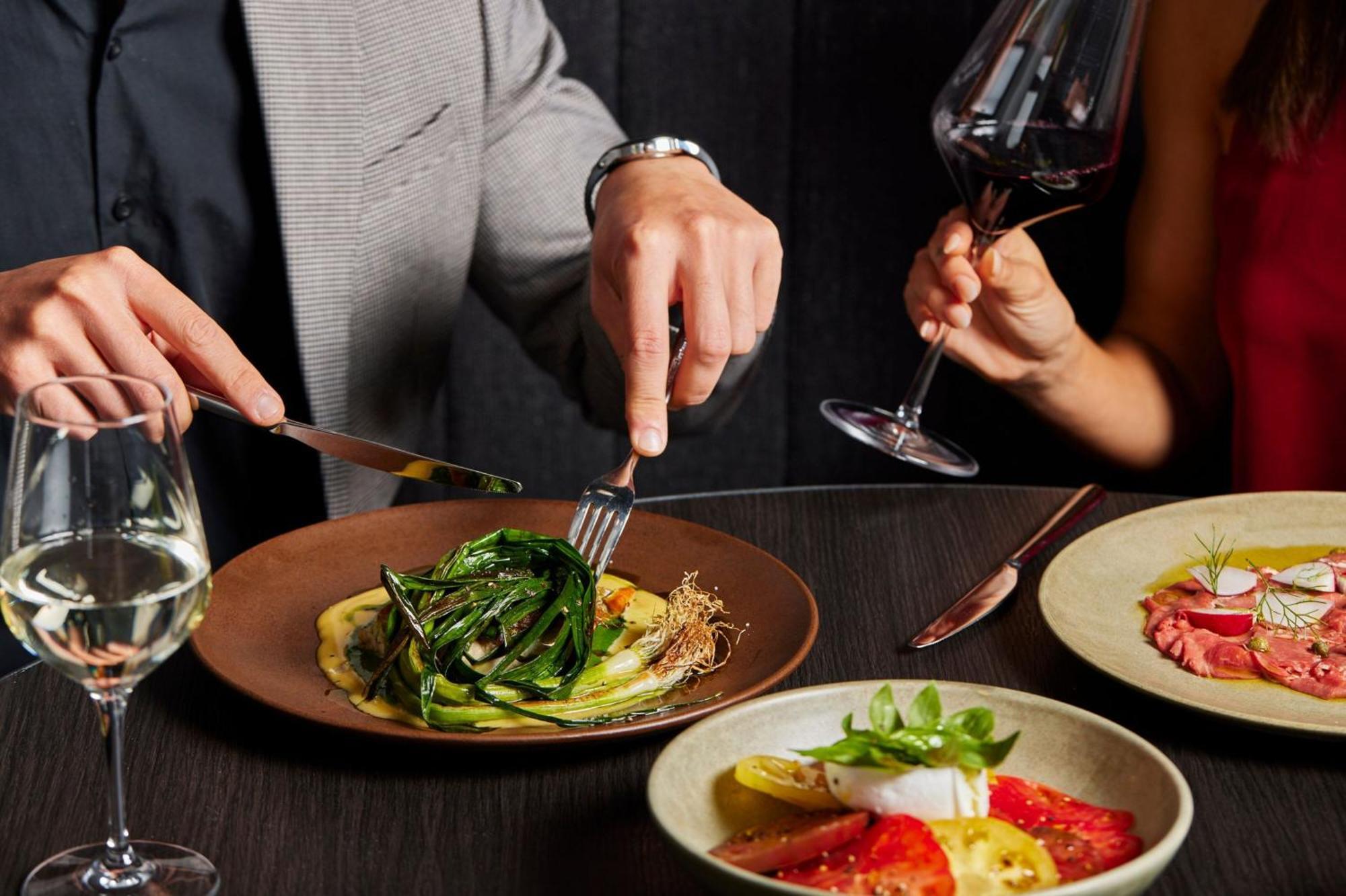 Melbourne Marriott Hotel Docklands Екстериор снимка A man using a knife and fork to cut into a meal